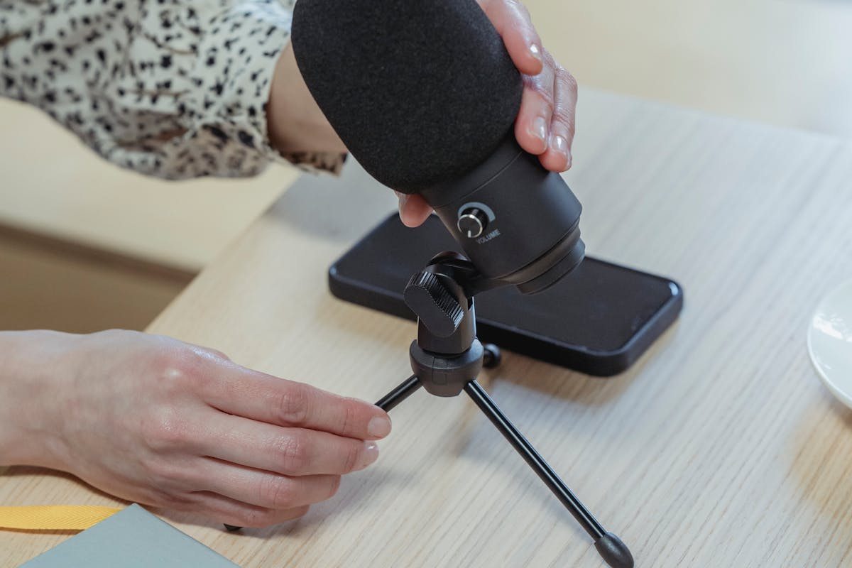 Anonymous woman putting microphone on table before conference in office