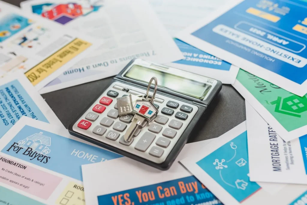 The keys to a building on top of a desk calculator among documents relating to real estate investments