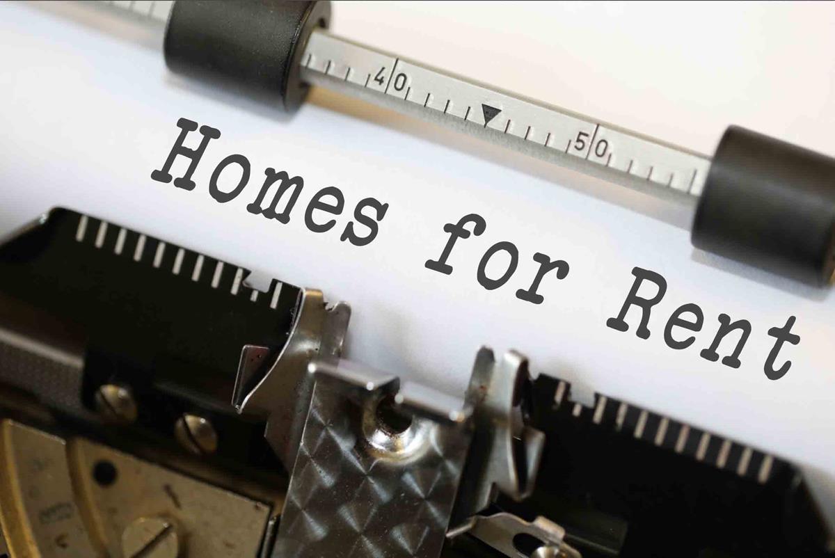 A close-up view of a typewriter with bold lettering on white paper stating homes for rent A close-up view of a typewriter with bold lettering on white paper stating homes for rent