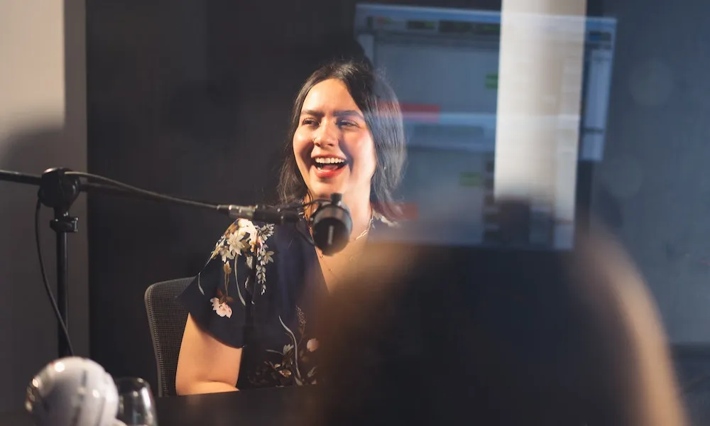 A real estate agent recording in a podcast booth