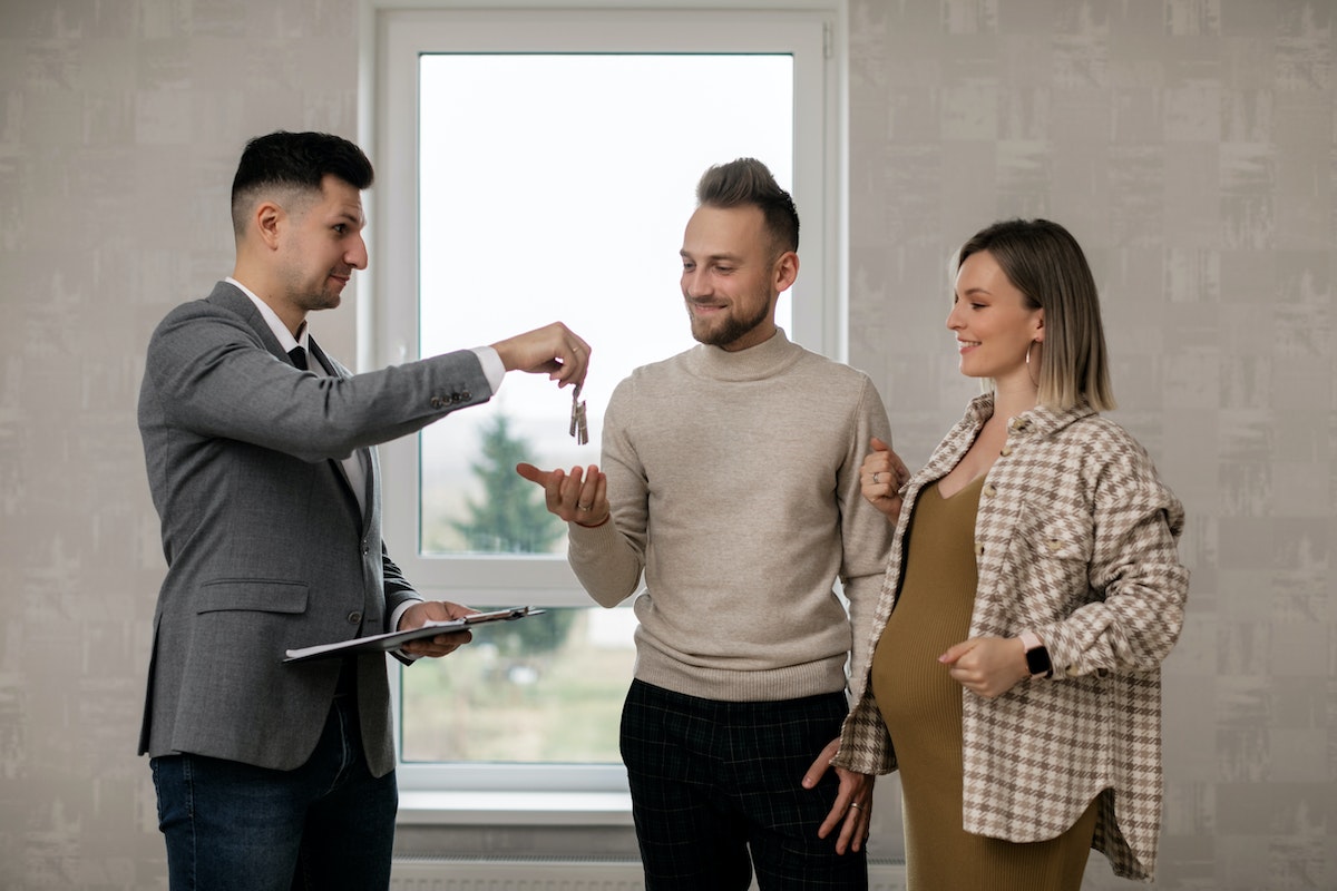 Real estate agent handing the key to the new homeowners