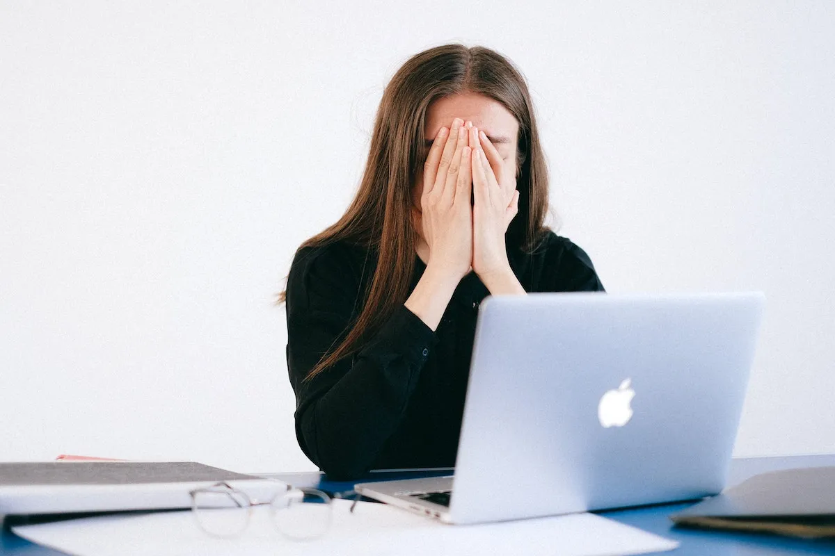 Woman-with-hands-on-her-face-in-front-of-a-laptop