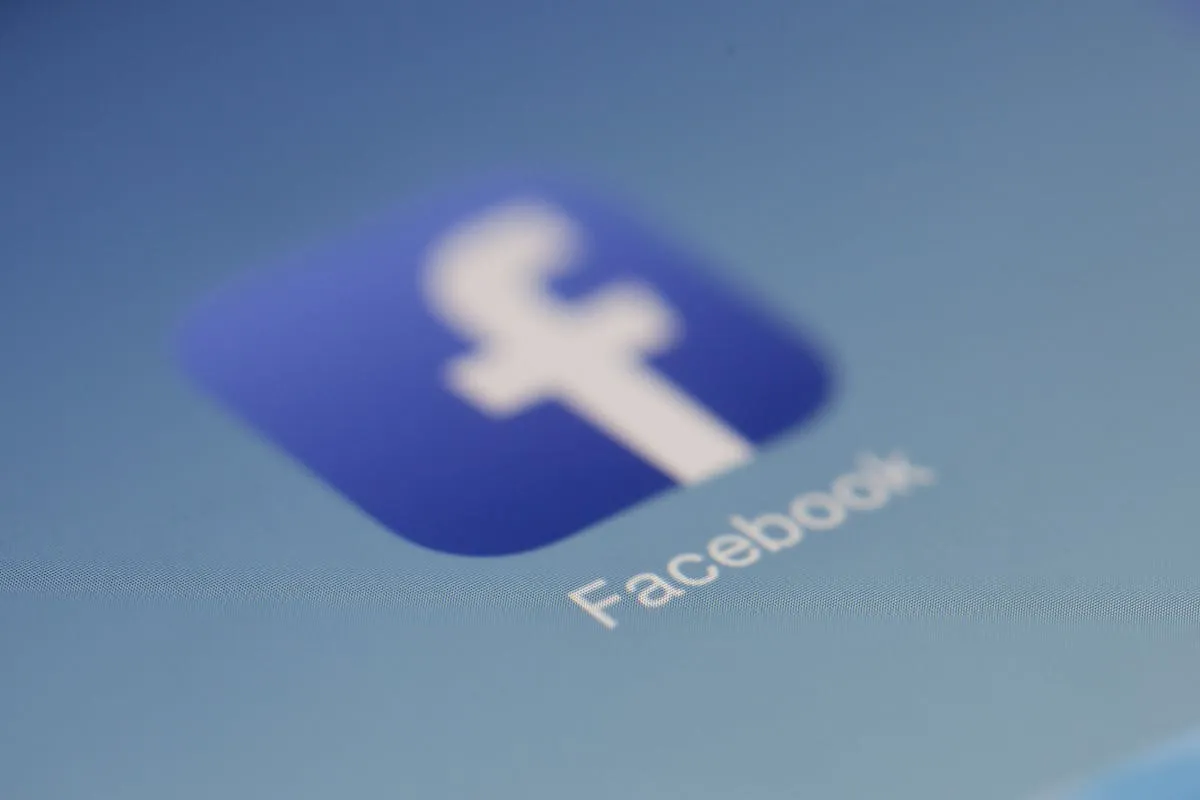 Blurred Facebook icon on a screen.
