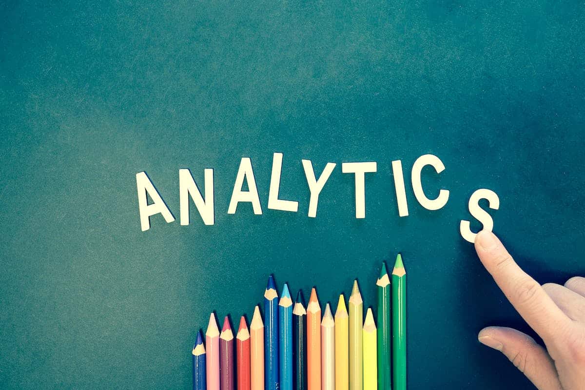 The word 'analytics' with colored pencils below it.