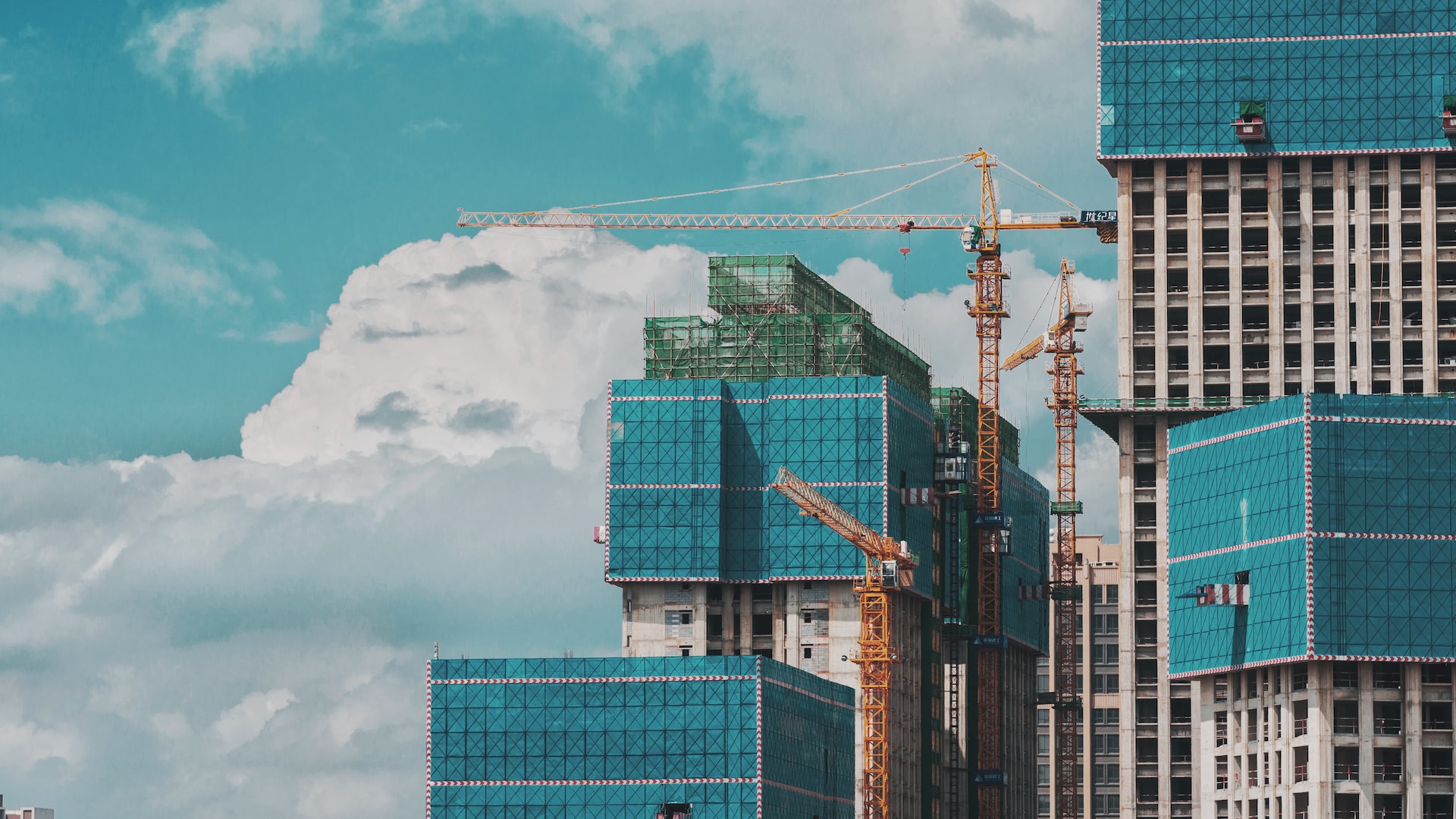 A group of tall buildings under a cloudy blue sky