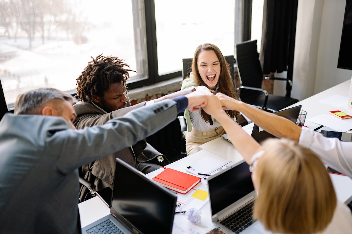 Real estate team triumphant colleagues doing a fist bump