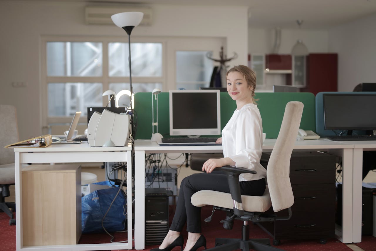 Elegant female employee sitting on chair in modern workplace