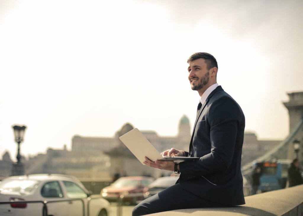 Man Wearing Black Suit While Using Laptop