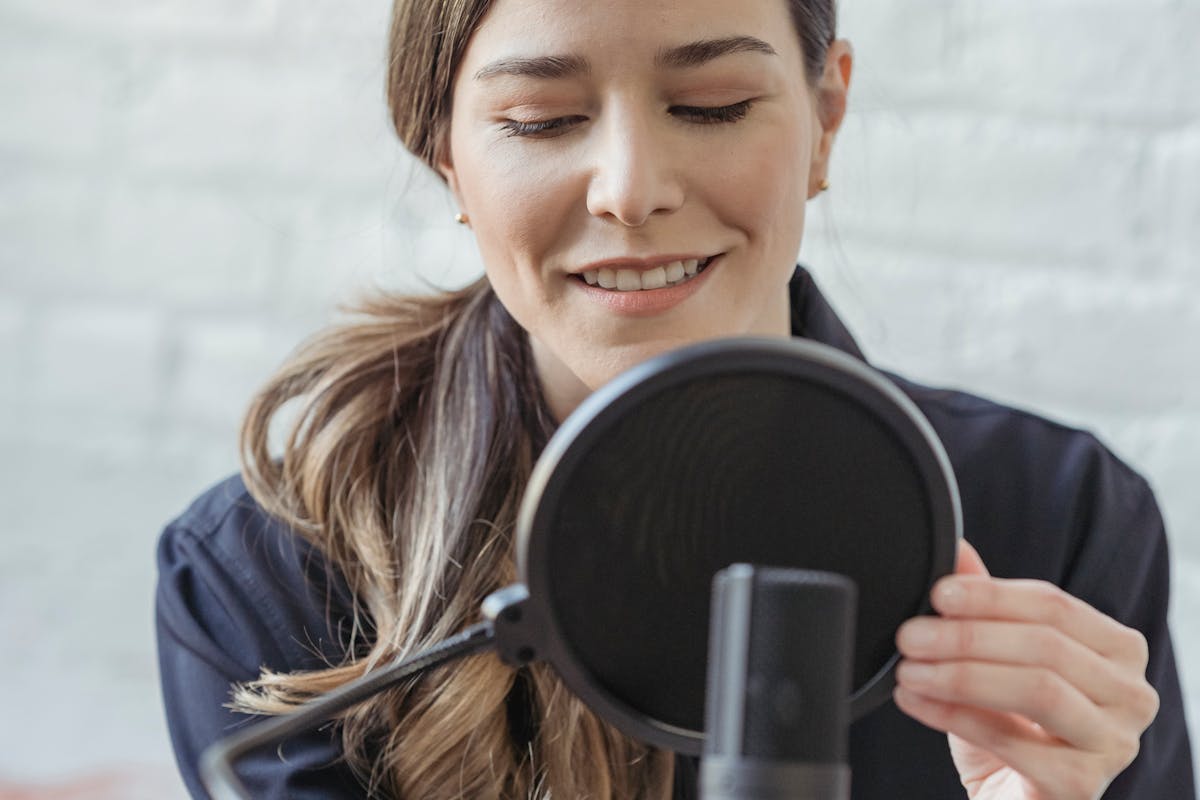 Woman Holding Condenser Microphone On Podcast